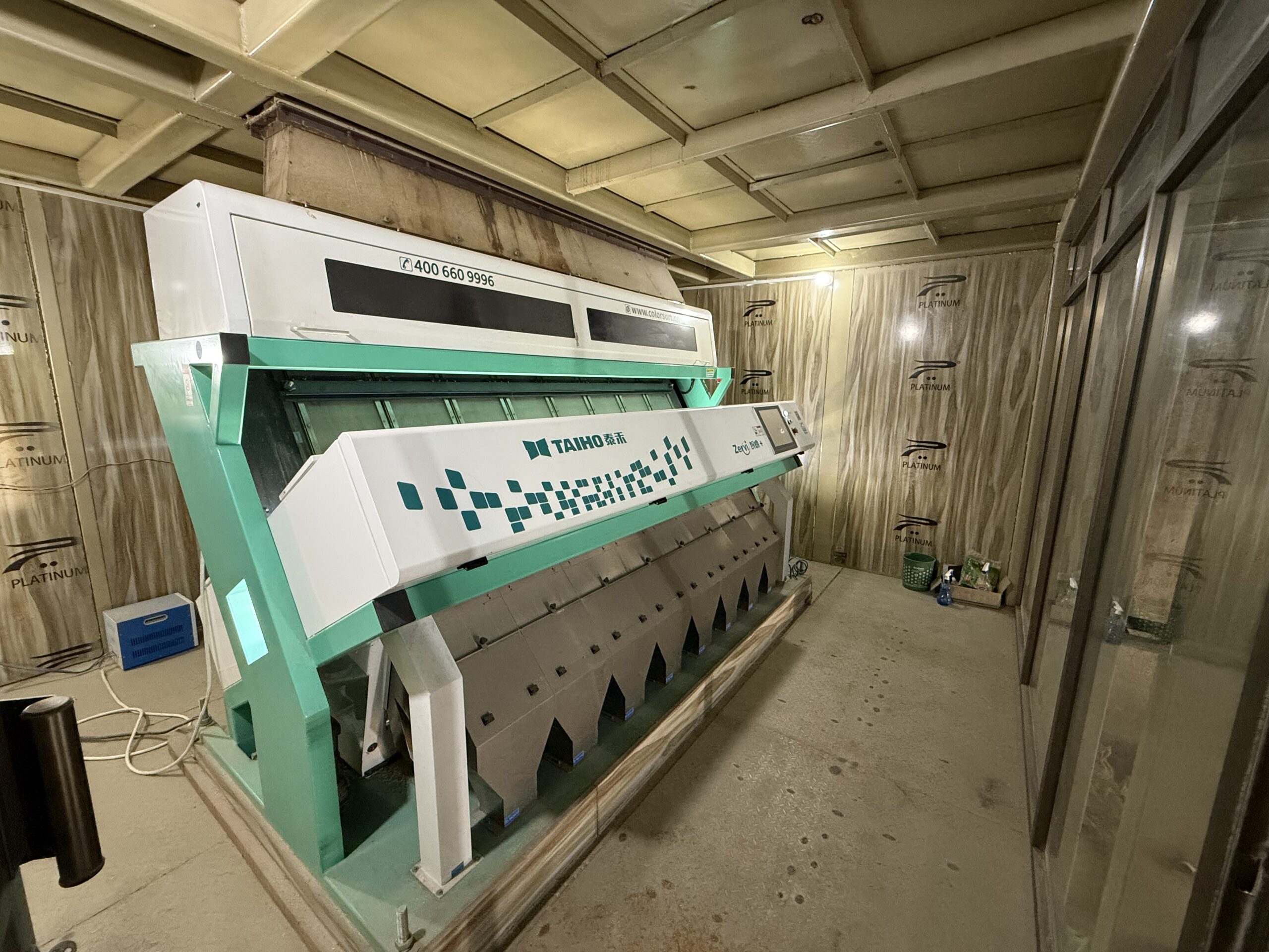 Modern rice color sorter machine used for grain quality inspection at Arham Rice Mills facility.